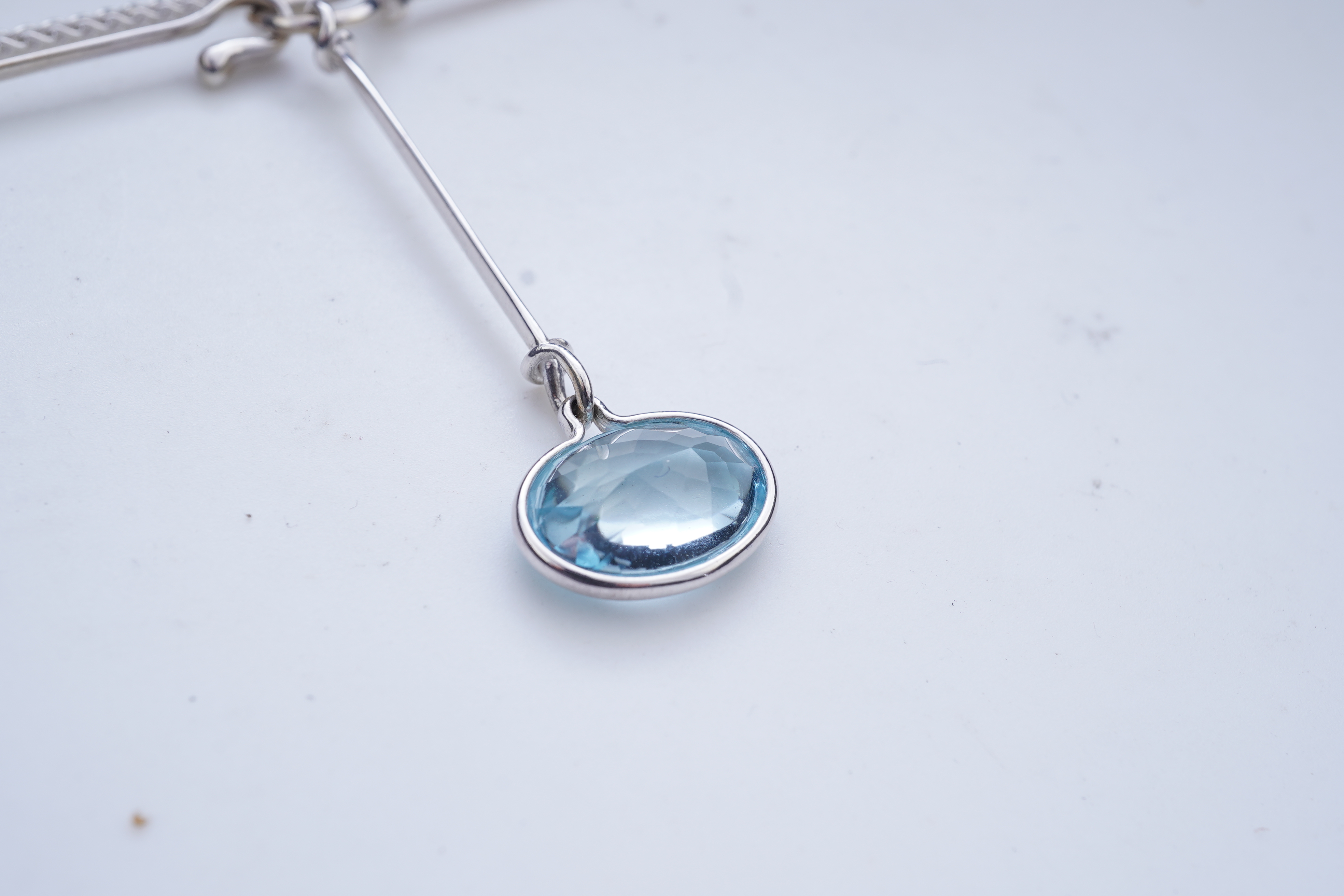 Georg Jensen, a blue topaz necklace, centring on a hook clasp suspending an oval blue topaz pendant, pendant length 5.5cm, necklace length 43cm, stamped GJ for Georg Jensen, 925S and European convention assay marks for s
